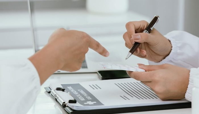 Admissions specialist reviewing treatment paperwork with an incoming patient