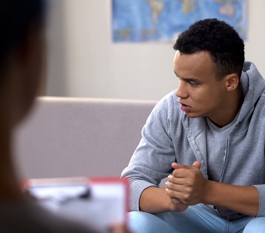 Young man talking with a counselor during a one-on-one drug rehab session